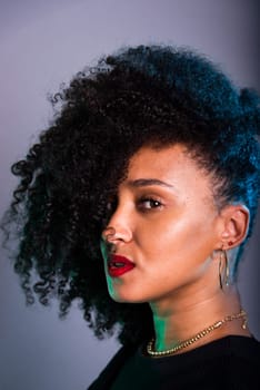 Vertical close-up portrait of beautiful young woman with hair to her face. Studio portrait.