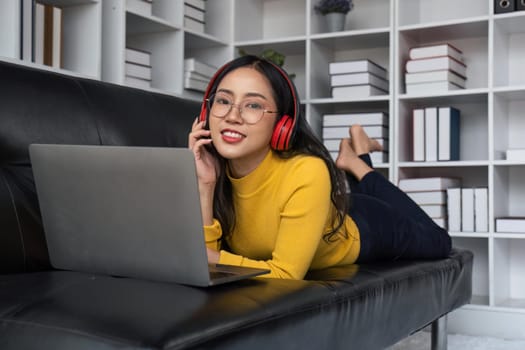asian beautiful woman smiling at home in headphones listen music at home. Use technology, lifestyle concept.