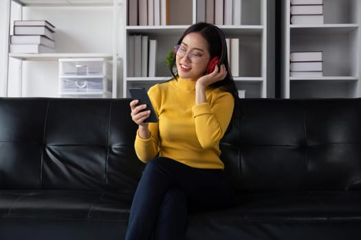 asian beautiful woman smiling at home in headphones listen music at home. Use technology, lifestyle concept.