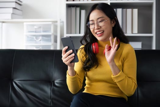 woman making video call on smartphone with family or friends happily.