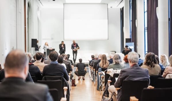 Business team leader receiving award prize at best business project competition event. Business and entrepreneurship award ceremony theme. Focus on unrecognizable people in audience