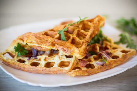 Egg omelette stuffed with onions and herbs, fried in the form of waffles, on a wooden table