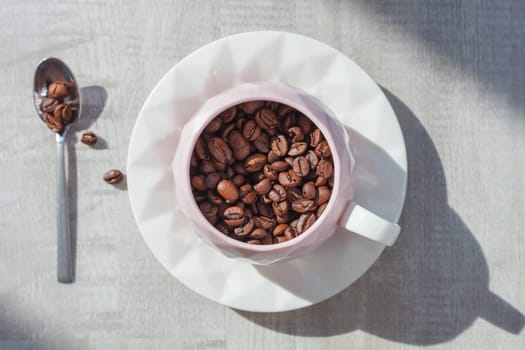 coffee beans in cup on the plate with spoon on table