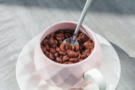 coffee beans in cup on the plate with spoon on table