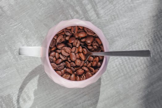 coffee beans in cup on the table with spoon on table