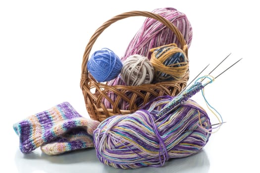 Colored threads, knitting needles and other items for hand knitting, isolated on a white background.