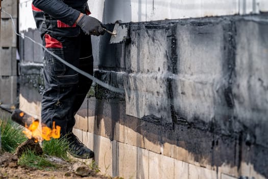 waterproofing of the wall with a covered asphalt belt during the construction of the house.