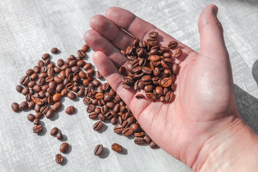 coffee beans in the man's hand fall on the table