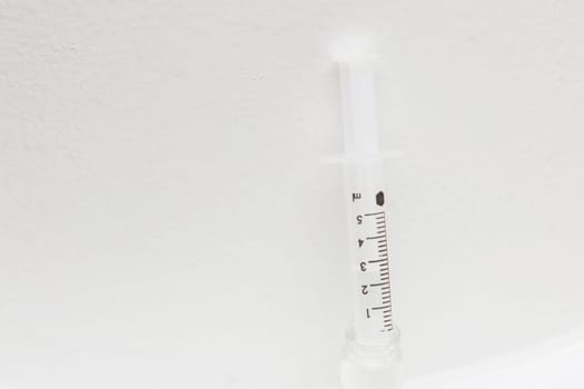 Injection syringe and open bottle with medicine on white background. Pharmoceutical concept.