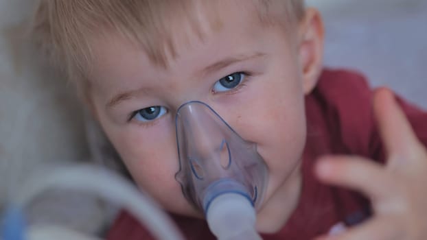 Funny boy breathing through an inhaler mask