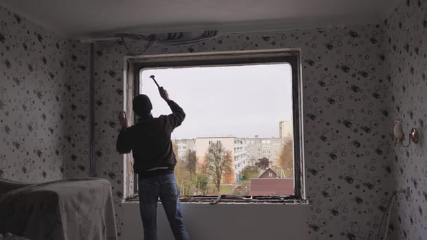 An employee removes an old wooden window