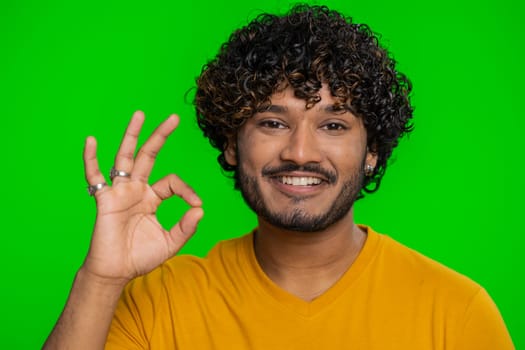 Ok. Joyful happy indian man in shirt looking approvingly at camera showing approve feedback gesture like sign positive something good. Handsome guy on chroma key background. People sincere emotion