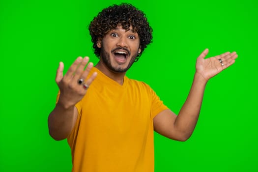 Come here, join us. Welcome. Hindu bearded man showing inviting gesture with hands, ask to join, beckoning to coming, gesturing hello, goodbye. Handsome indian guy isolated on chroma key background