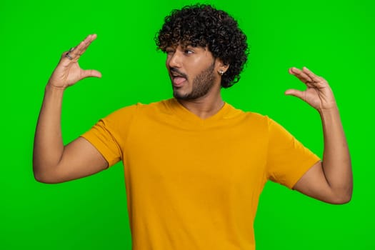 Indian man showing bla-bla-bla nonsense gesture with hands and rolling eyes, gossips, empty promises, blah concept, not interested in the conversation. Liars. Hindu guy on green chroma key background