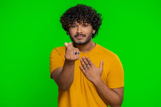 Give me money, please. Indian man rubbing fingers show cash gesture, demands to pay back the debt, take loan, do shopping, begging, investment reward. Hindu guy isolated on green chroma key background