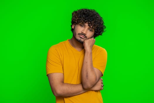 Tired bored young indian man indifferent expression, exhausted of tedious story, not interested in communication talk, displeasure, uninteresting. Hindu guy isolated on green chroma key background