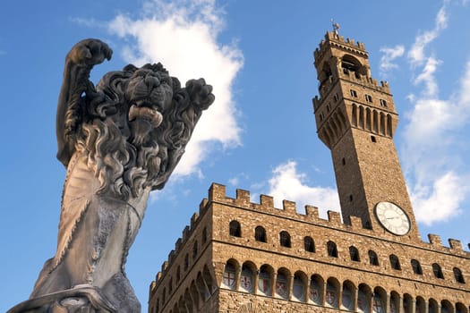 06 Dec, 2021 - Florence, Italy. Sculpture Pieta depicting a rampant lion with a Roman sculpture head in its mouth by contemporary Italian artist Francesco Vezzoli installed on Piazza della Signoria with Palazzo Vecchio on background.