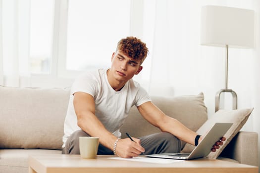 man interior typing caucasian laptop lifestyle home happy adult chat sitting cup using student curly computer person business