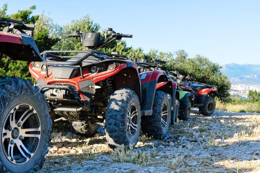 Parked ATV and UTV, mountain road. parked in a row several atv quad bikes extreme outdoor adventure concept