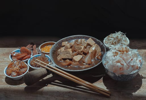 Chinese steamed flat wide rice noodles with Braised pork, Tofu, Crisp squid in sweet soy sauce and Bean sprout, Chinese sausage sliced, Fried dried shrimp and Pickle turnip serve with pickled chili. Asian food style, Space for text, Selective focus.