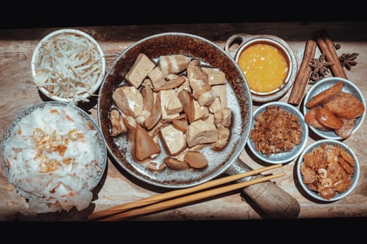 Chinese steamed flat wide rice noodles with Braised pork, Tofu, Crisp squid in sweet soy sauce and Bean sprout, Chinese sausage sliced, Fried dried shrimp and Pickle turnip serve with pickled chili. Asian food style, Top view, Selective focus.