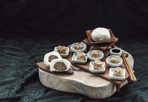 Steamed buns with minced pork filling and Pork shumai or Chinese steamed dumpling served with sour sauce and wooden chopstick. Chinese Dim Sum. Space for text, Selective Focus.