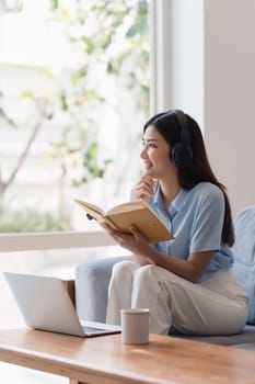 Attractive Asian woman resting comfortable living room and reading book, Relax, Sofa, Lifestyle.