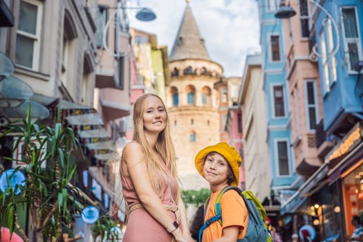 Portrait of beautiful mother and son tourists with view of Galata tower in Beyoglu, Istanbul, Turkey. Turkiye. Traveling with kids concept.