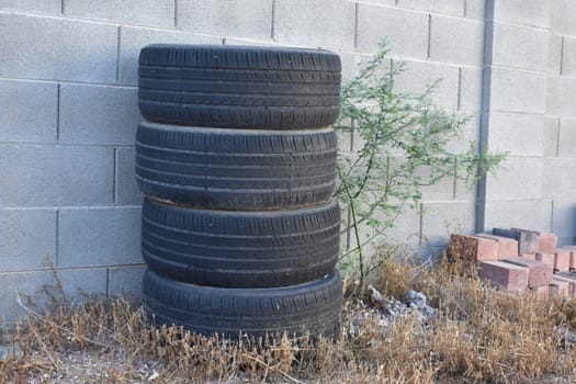 Stack of Four Used Tires near Cinder Block Wall. High quality photo