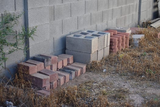Assorted Stacks of Bricks by a Cinder Block Wall . High quality photo