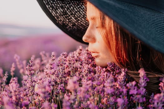 Close up portrait of young beautiful woman in a white dress and a hat is walking in the lavender field and smelling lavender bouquet.