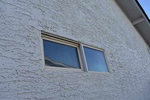 Exterior of Bathroom Shower Window on White Stucco House. High quality photo