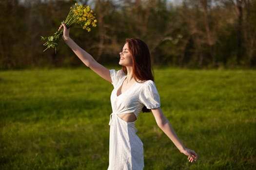 happy woman in a light dress rejoices in life with a bouquet of flowers in her hands. High quality photo