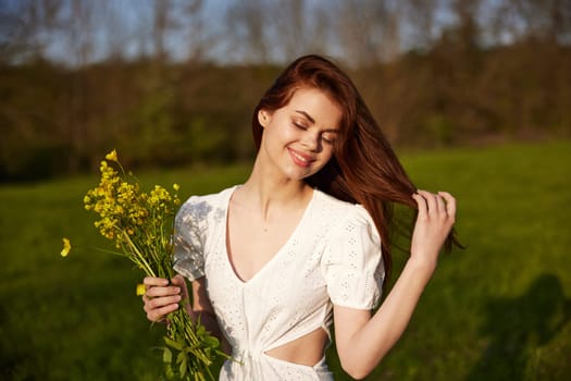 portrait of a happy woman with a bouquet of buttercups walking in the field. High quality photo