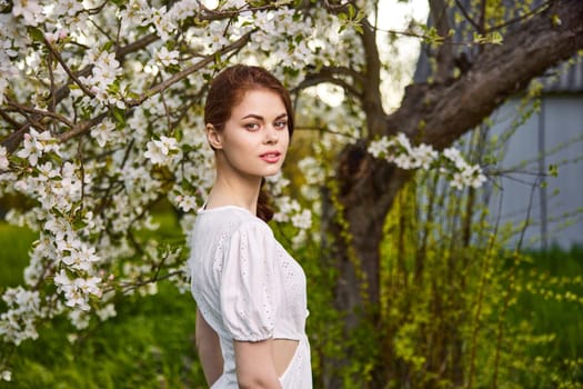 beautiful woman standing near blossoming bush. High quality photo