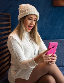 blonde woman gets a big surprise when looking at the cell phone. High quality photo