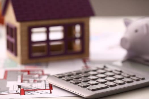 Architectural house plan house layout and calculator on table. Calculation of house construction concept