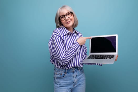 middle aged woman mastering laptop with mockup on bright studio background.