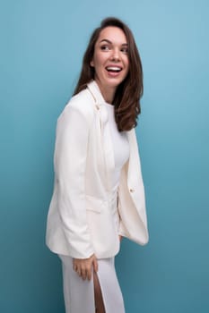 coquette woman with dark long hair in elegant white dress on studio background.