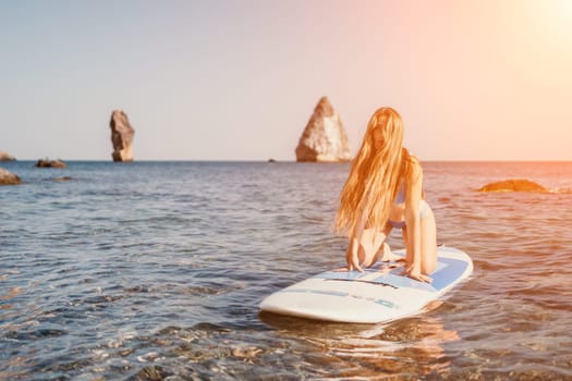 Close up shot of happy young caucasian woman looking at camera and smiling. Cute woman portrait in bikini posing on a volcanic rock high above the sea