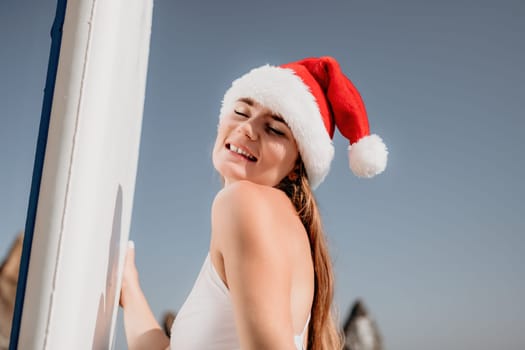 Close up shot of happy young caucasian woman looking at camera and smiling. Cute woman portrait in bikini posing on a volcanic rock high above the sea