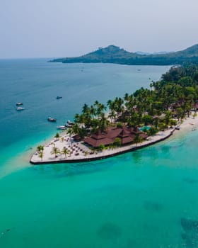 Koh Mook tropical Island in the Andaman Sea in Thailand, tropical beach with white sand and turqouse colored ocean with coconut palm trees. wooden bungalows on the beach