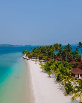 Koh Mook tropical Island in the Andaman Sea in Thailand, tropical beach with white sand and turqouse colored ocean with coconut palm trees.
