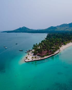 Koh Mook tropical Island in the Andaman Sea in Thailand, tropical beach with white sand and turqouse colored ocean with coconut palm trees. Drone aerial view of an tropical Island