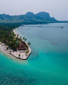 Koh Mook tropical Island in the Andaman Sea in Thailand, tropical beach with white sand and turqouse colored ocean with coconut palm trees. Drone aerial view of an tropical Island