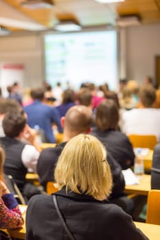 Round table discussion at business and entrepreneurship workshop. Audience at the conference hall. Presentation in lecture hall at university. Participants listening to lecture and making notes.