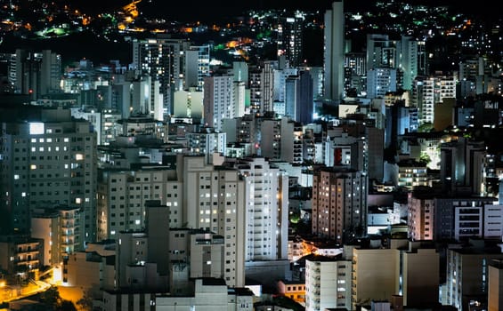 View of the city center with compressed skyscrapers, illuminated by lights at dusk.