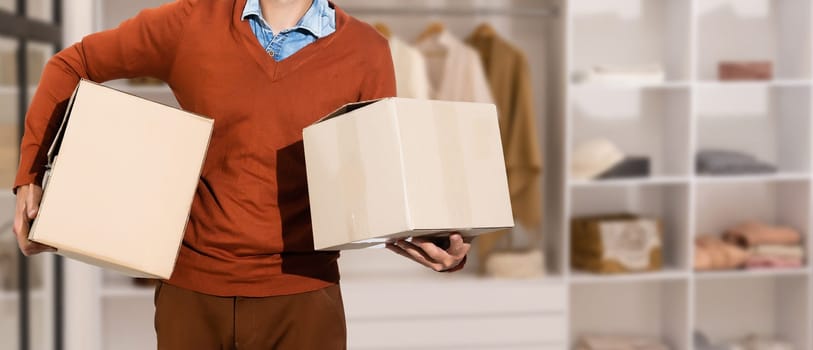 young man carrying three carton boxes.