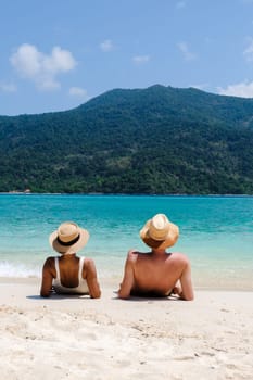 Couple of men and women on the beach of Koh Lipe Island Thailand, a tropical Island with a blue ocean and white soft sand. Ko Lipe Island Thailand