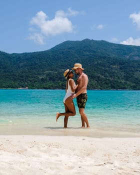 Couple on the beach of Koh Lipe Island Thailand, a tropical Island with a blue ocean and white soft sand. Ko Lipe Island Thailand on a sunny day